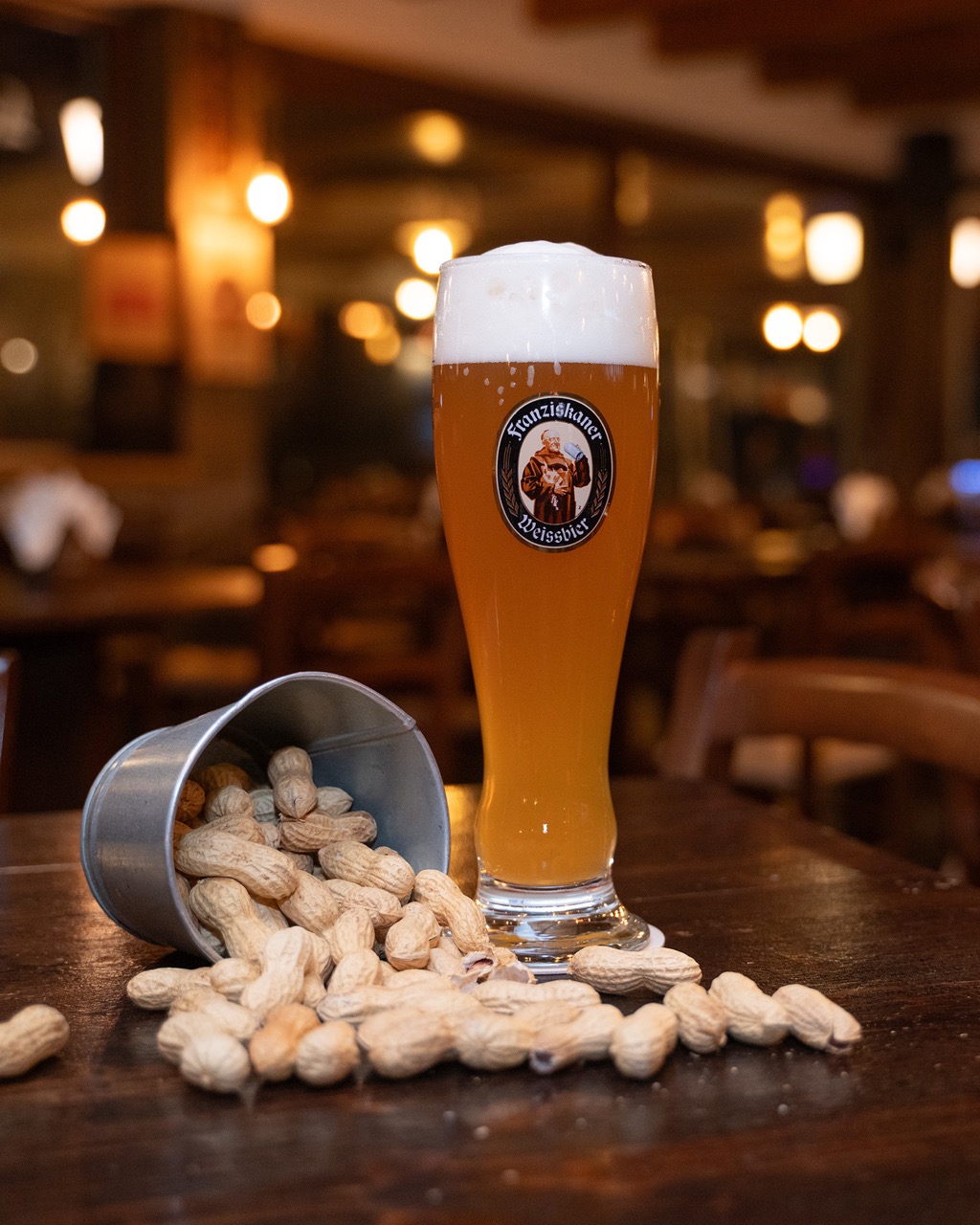 Birra weiss servita con arachidi sul tavolo del locale