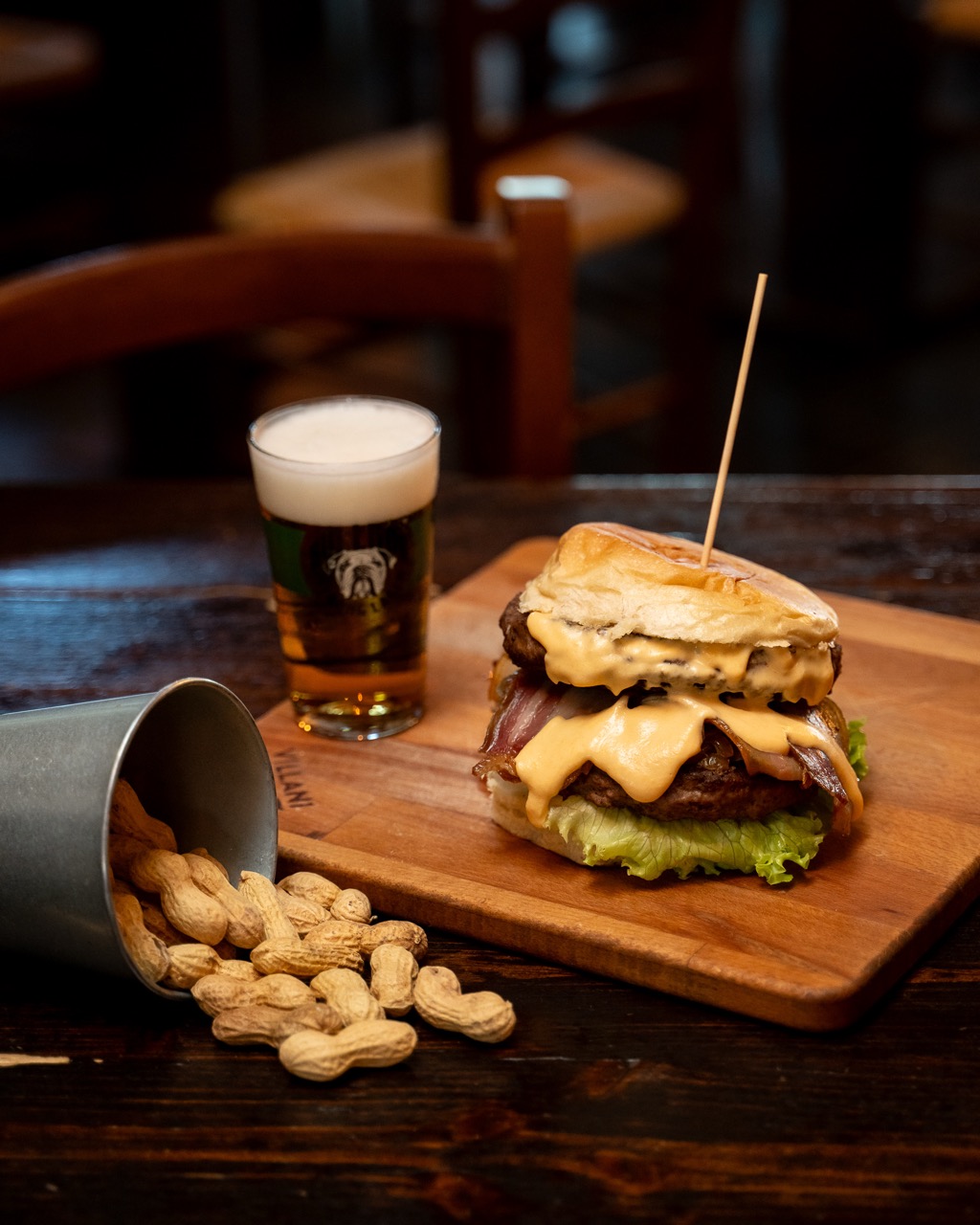 Hamburger gourmet servito con birra e arachidi
